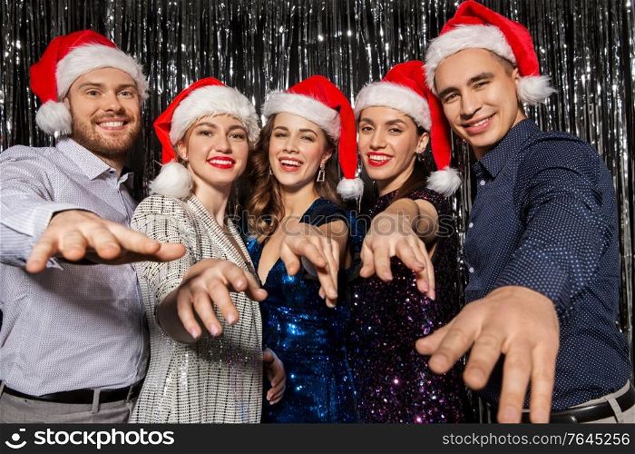 celebration, people and holiday concept - happy friends in santa hats at christmas party. happy friends in santa hats at christmas party