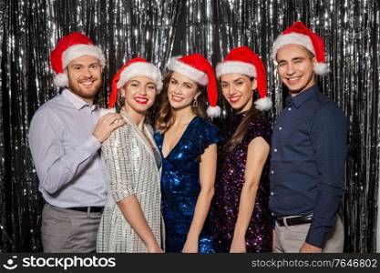celebration, people and holiday concept - happy friends in santa hats at christmas party. happy friends in santa hats at christmas party