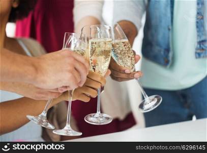 celebration, people and holidays concept - close up of friends clinking glasses of champagne at party. friends clinking glasses of champagne at party