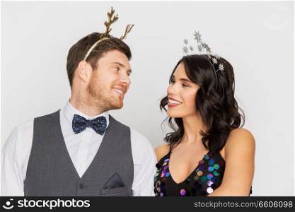 celebration, people and holidays concept - happy couple with christmas or new year party props. couple with christmas or new year party props
