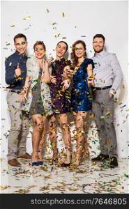celebration, people and holidays concept - happy friends at party under falling confetti over white background. happy friends at party under confetti over white