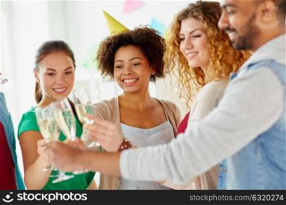 celebration, people and holidays concept - happy friends clinking glasses of champagne at birthday party. friends clinking glasses of champagne at party