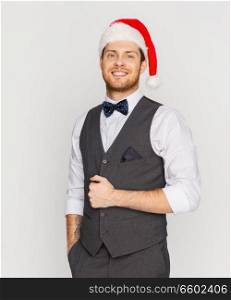 celebration, people and holidays concept - happy man in santa hat and suit at christmas. happy man in santa hat and suit at christmas