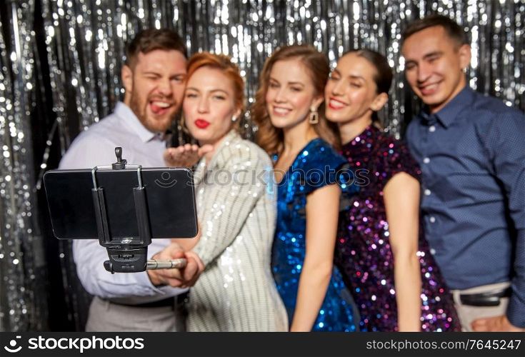celebration, technology and holiday concept - happy friends taking selfie by smartphone at party. happy friends taking selfie by smartphone at party
