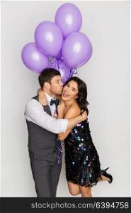 celebration, valentines day and holidays concept - happy couple with ultra violet balloons kissing and hugging at birthday party. happy couple with violet balloons kissing at party
