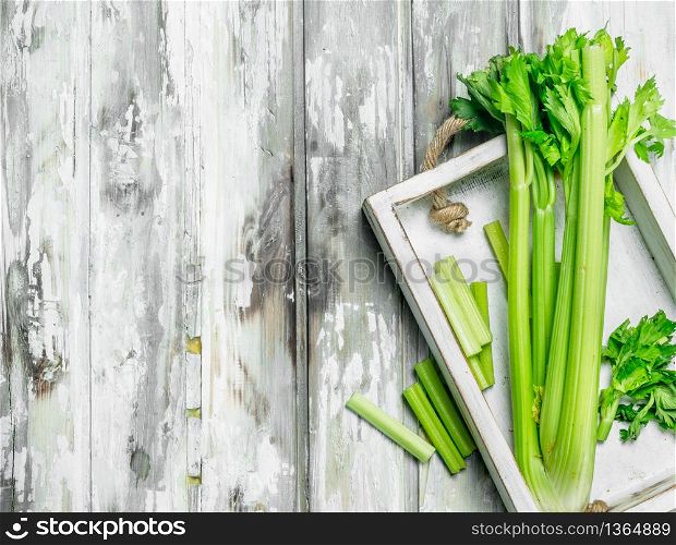 Celery for the tray. On white wooden background. Celery for the tray.