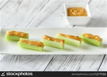 Celery stalks with peanut butter on serving plate
