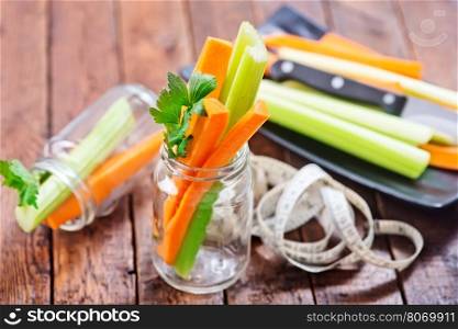 celery with carrot on plate and on a table