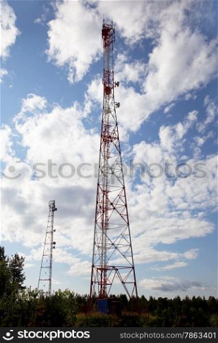 Cell tower in forest against the background of blue sky