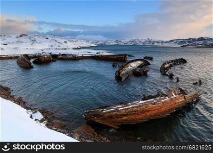 Cemetery of small fishing boats in Teriberke at sunrise. Murmansk region, Russia.&#xA;