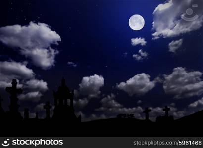 Cemetery under night cloudy sky with moon