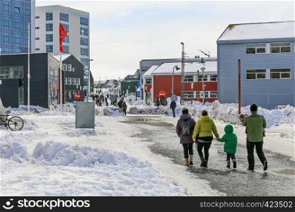 Central pedestrian street with modern building and walking people of Nuuk city, Greenland