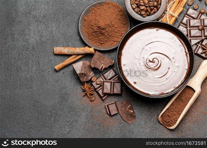 ceramic bowl of chocolate cream or melted chocolate and pieces of chocolate isolated on dark concrete background or table. ceramic bowl of chocolate cream or melted chocolate and pieces of chocolate isolated on dark concrete background
