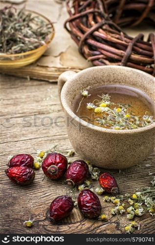 ceramic cup brewed with rose hips and chamomile in vintage rustic style. healing broth
