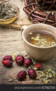 ceramic cup brewed with rose hips and chamomile in vintage rustic style. healing broth