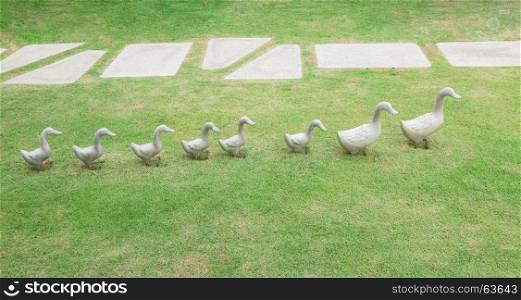 Ceramic ducks decoration sculpture on green grass