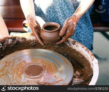 Ceramic jug in dirty potter&rsquo;s hands