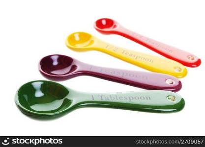 Ceramic measuring spoons in four bright colors. Shot on white background.