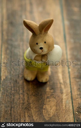 Ceramic painted rabbits for Easter decoration on a wooden background