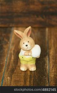 Ceramic painted rabbits for Easter decoration on a wooden background