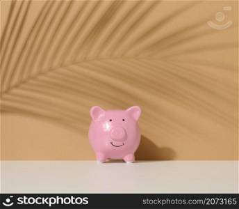ceramic pink piggy bank on a brown background. Concept of increasing income from bank accounts, savings