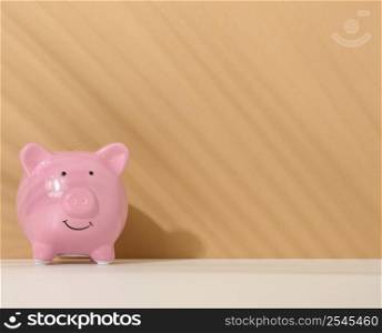 ceramic pink piggy bank on a brown background. Concept of increasing income from bank accounts, savings. Copy space