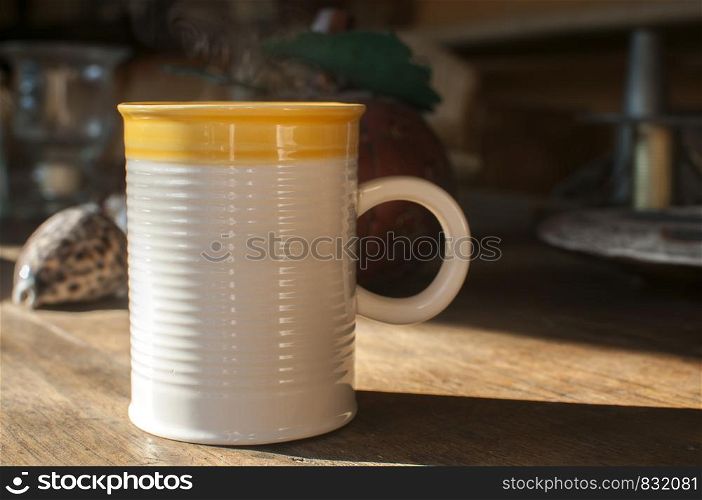 Ceramic tea mug closeup on wooden board surface