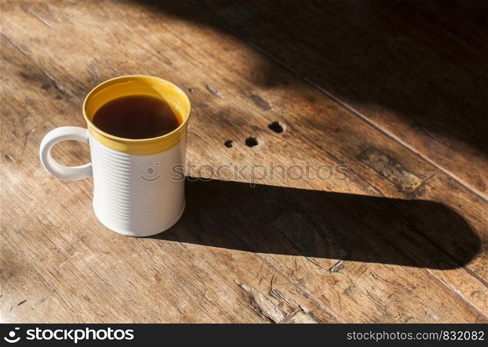 Ceramic tea mug closeup on wooden board surface
