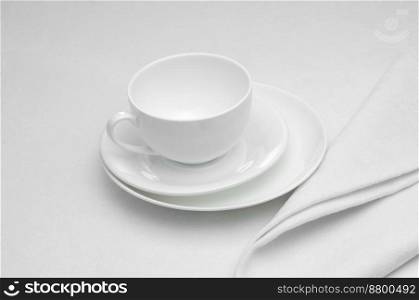 ceramic white cup with napkin on white background. white kitchen utensils