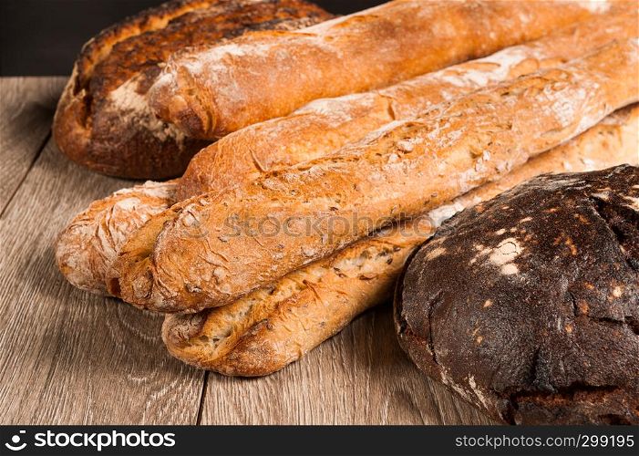 cereal baguette and fig bread with prunes on dark background