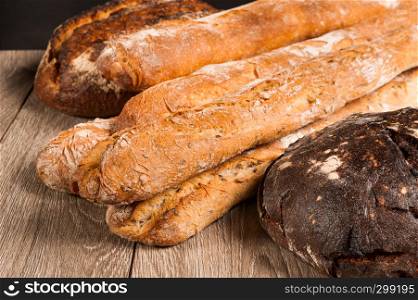 cereal baguette and fig bread with prunes on dark background