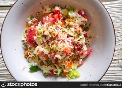 Cesar caesar salad with tomato cheese lettuce and sauce