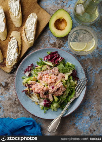 Ceviche is a traditional dish from Peru. Salmon marinated in lemon with fresh lettuce, avocado and onions. Peruvian food.