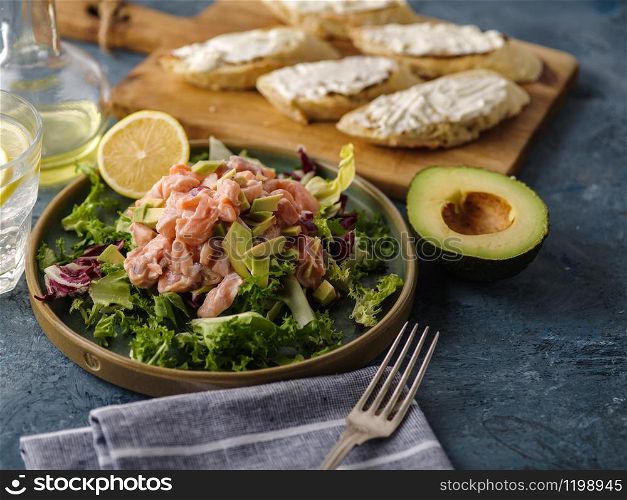 Ceviche is a traditional dish from Peru. Salmon marinated in lemon with fresh lettuce, avocado and onions. Peruvian food.