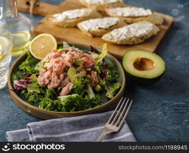 Ceviche is a traditional dish from Peru. Salmon marinated in lemon with fresh lettuce, avocado and onions. Peruvian food.