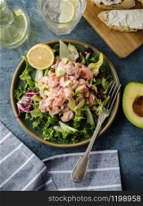 Ceviche is a traditional dish from Peru. Salmon marinated in lemon with fresh lettuce, avocado and onions. Peruvian food.