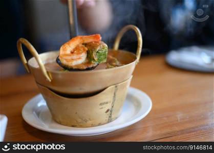 Cha-om sour soup with shrimp in the pot. Selective focus.