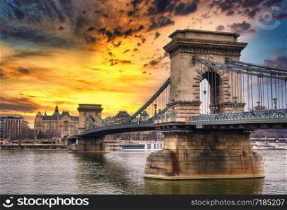 Chain bridge on Danube river in Budapest city in Hungary. Urban landscape panorama with old buildings at sunset.