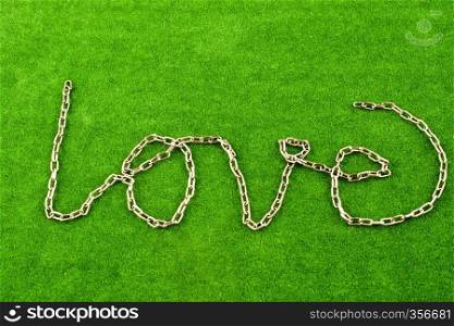 Chain form the word LOVE on grass background