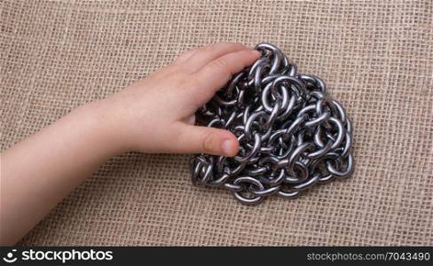Chain made of metal in hand on canvas background