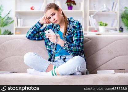 Chained female student with mobile sitting on the sofa