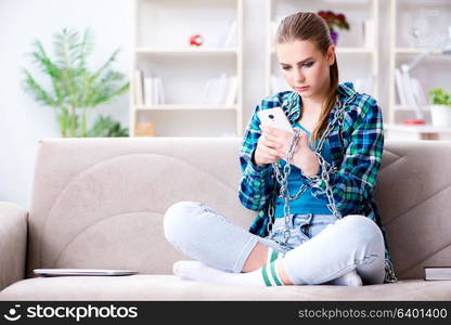 Chained female student with mobile sitting on the sofa