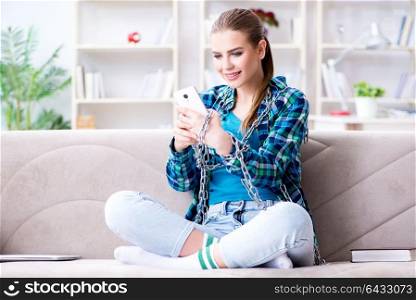 Chained female student with mobile sitting on the sofa