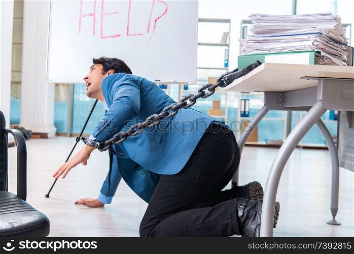 Chained male employee unhappy with excessive work 