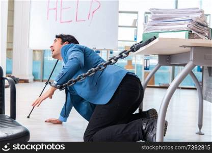 Chained male employee unhappy with excessive work 