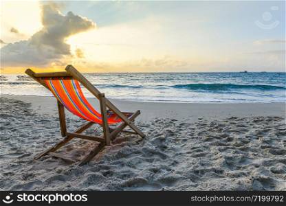 Chair beach on sand in the summer vacation nature travel beautiful summer landscape with / Tropical Holiday sunset or sunrise on the beach with sea and yellow sky ocean background