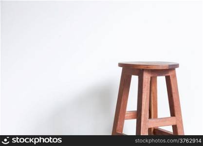 Chair made ??of wood in a room with white walls.