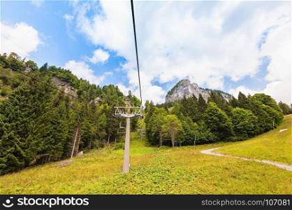 Chairlift ski lift in European Alps. Transporting hikers in summer season.