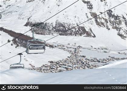 Chairlifts running above a mountain village - shot in Livigno, Italian Alps