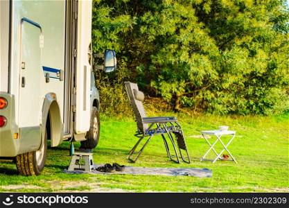 Chairs and table at caravan on green nature. Wild camping. Holidays and traveling in motor home.. Rv caravan camping on green nature